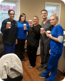 Group of dentistry team members drinking coffee in dental office