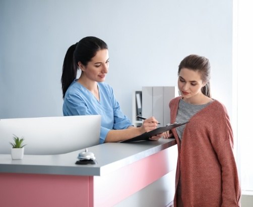 Dental team member explaining the cost of dental emergencies to dentistry patient