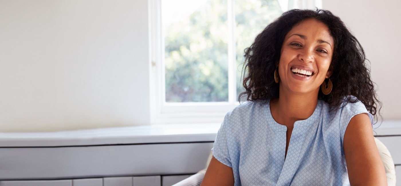 Woman sharing smile after tooth replacement with dental implants