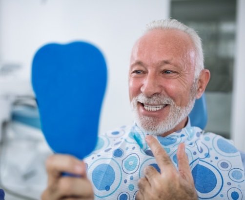 Man with metal free dental restorations looking at smile