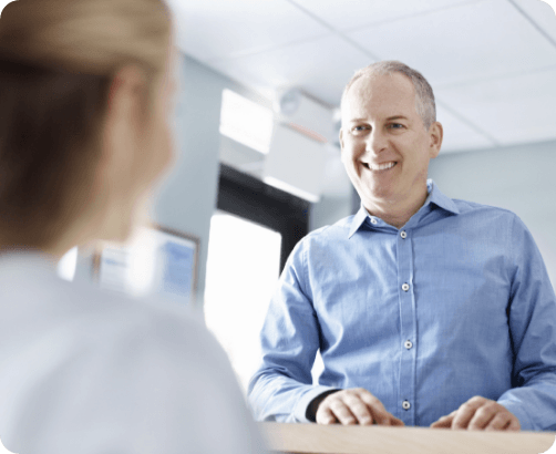 Man talking to team member at front desk