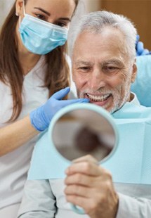 a patient checking his smile after replacing missing teeth