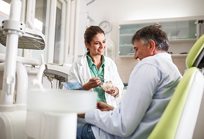 Dentist smiling at patient in treatment room