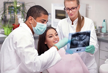 Dentist reviewing smiling patient's X-ray