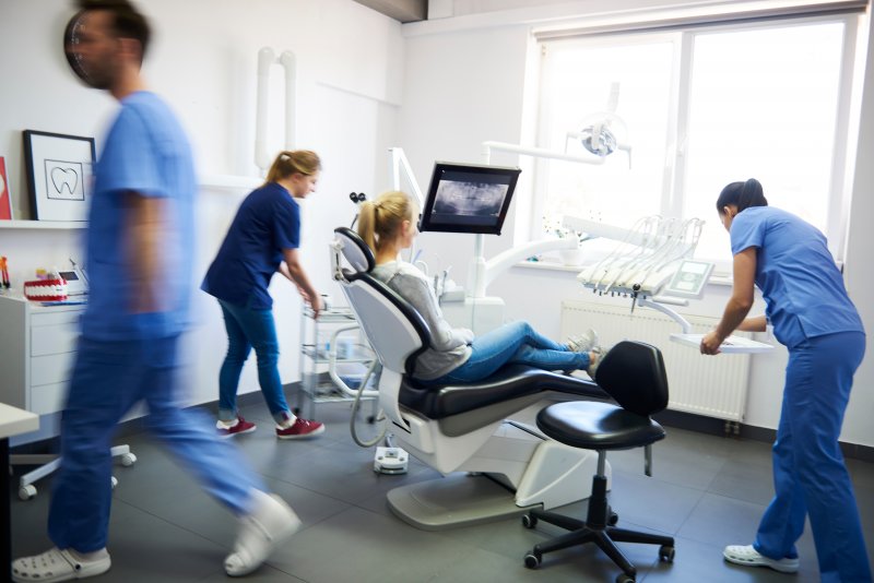 dentists moving rapidly around a patient