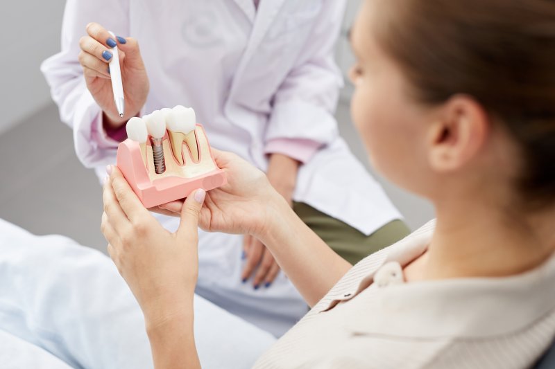 A dentist using a model to explain dental implant treatment